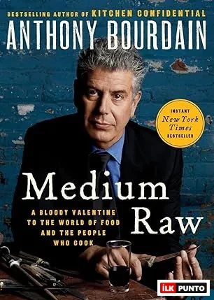 Anthony Bourdain'in Medium Raw adlı kitabının kapağında, gri saçlı, takım elbiseli yazar okuyucuya bakarken, önünde bir kadeh içki ve masa üzerinde çeşitli mutfak aletleri görülüyor, bu görüntü onun yemek dünyasındaki özgün yerini ve şef kişiliğini yansıtıyor.