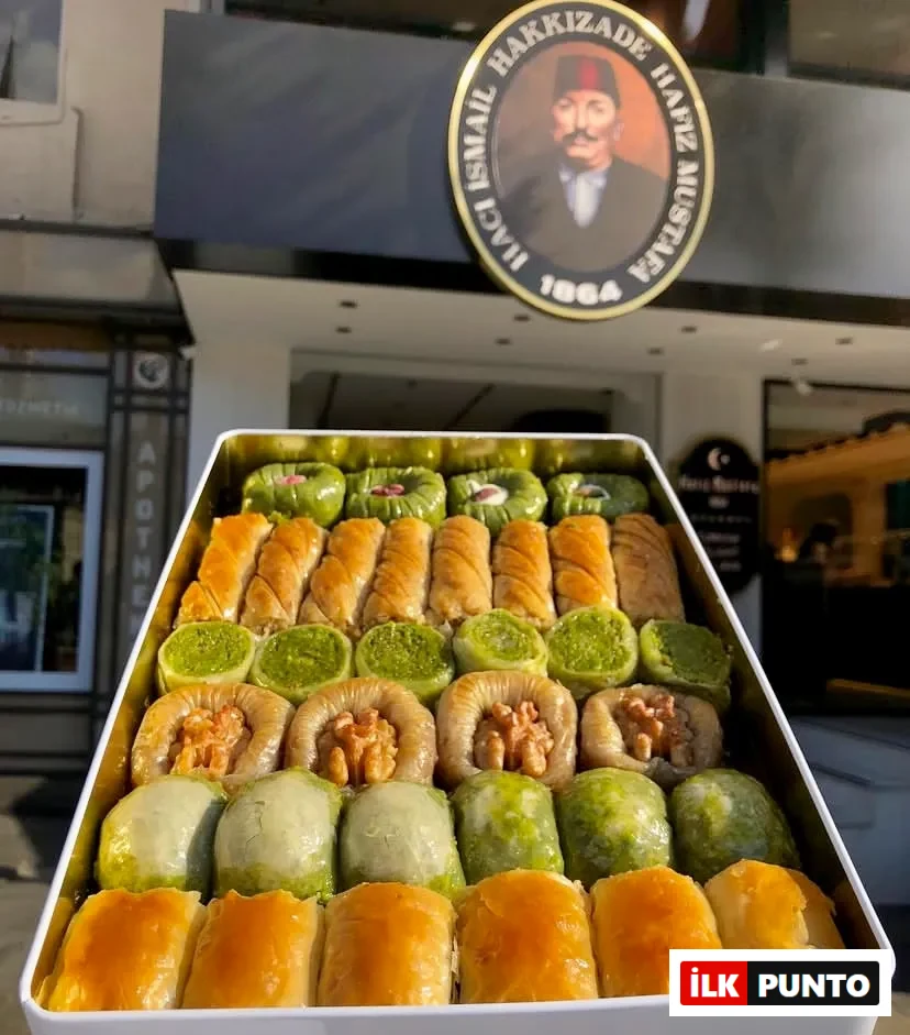 Tarihi Hafız Mustafa 1864 tabelası önünde sergilenen Hakkızade logolu beyaz metal kutuda; fıstıklı sarma, cevizli ve klasik dilimlerden oluşan, Türk tatlı kültürünün eşsiz lezzetini yansıtan çıtır baklava seçkisi sunuluyor.