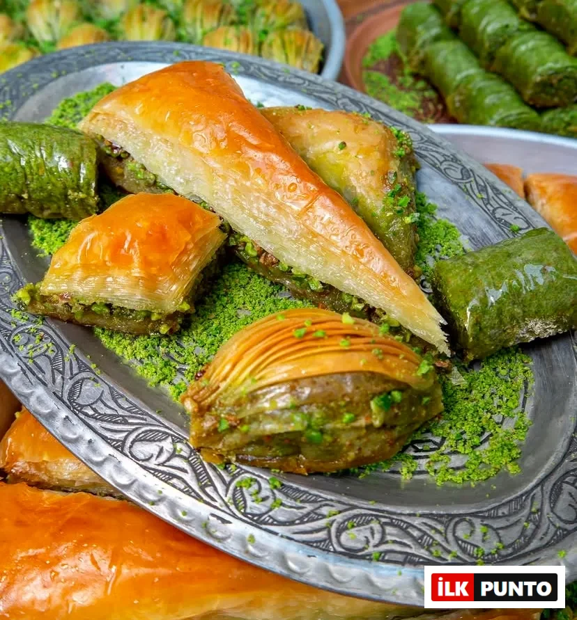 İşlemeli gümüş tepside sergilenen, şerbeti parlayan çıtır havuç dilimi, fıstıklı midye, klasik kare ve yemyeşil fıstıklı dürüm baklavalar. Toz Antep fıstığıyla süslenen bu tatlılar, asırlık Türk mutfağının eşsiz lezzet mirasını