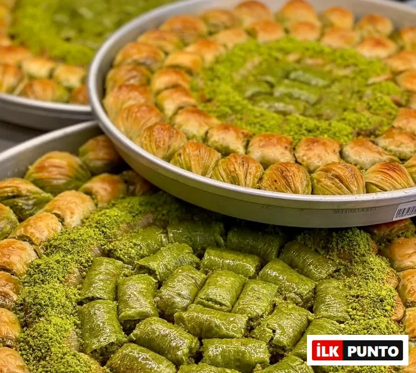 Yuvarlak metal tepsilerde dizilmiş, dışı çıtır yufkalı midye baklavalarla çevrili, ortası yoğun Antep fıstığı ve yemyeşil fıstıklı dürüm dolgulu enfes tatlılar. Türk tatlı geleneğinin ustalığını yansıtan, zengin dokulu ve iştah açıcı bir
