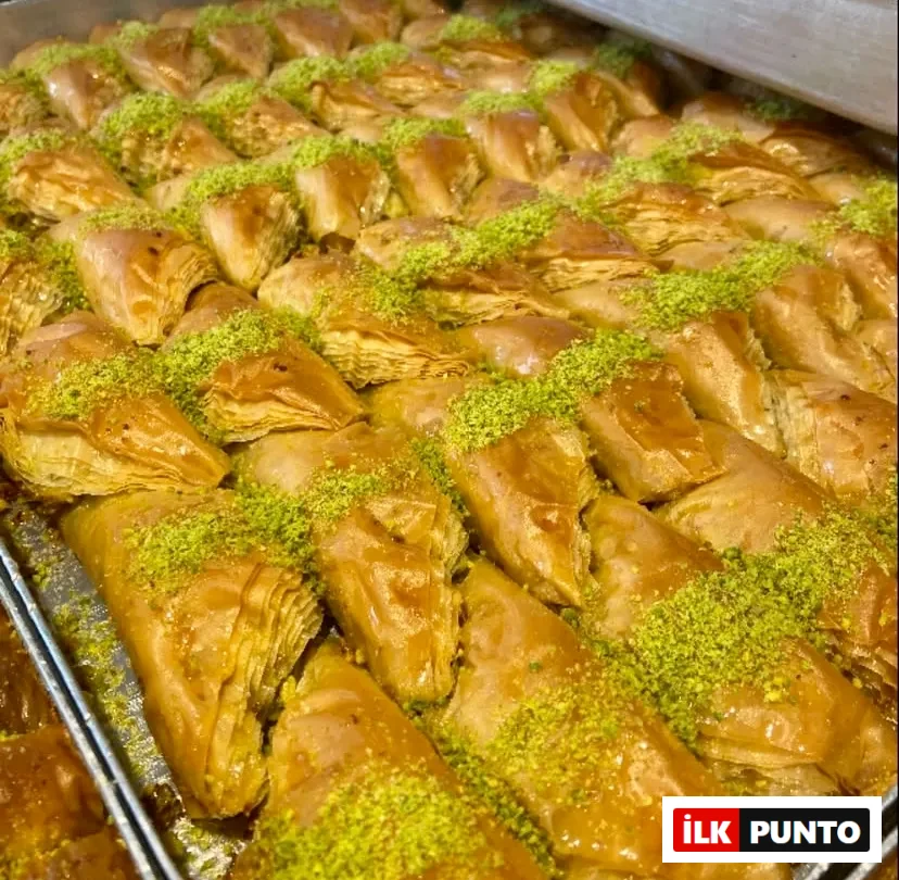 Büyük metal tepsiye dizilen, nar gibi kızarmış altın sarısı üçgen dilim baklavalar şerbetiyle parlıyor. İncecik katmanlı çıtır yufkaların üzerine bolca dökülen parlak yeşil Antep fıstığı tozu, geleneksel Türk tatlı kültürünü gözler