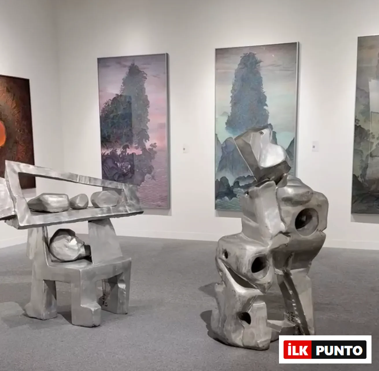 Abu Dhabi Art’ta çağdaş heykel yerleştirmeleri ve arka planda büyük ölçekli resimlerin yer aldığı sergi alanı