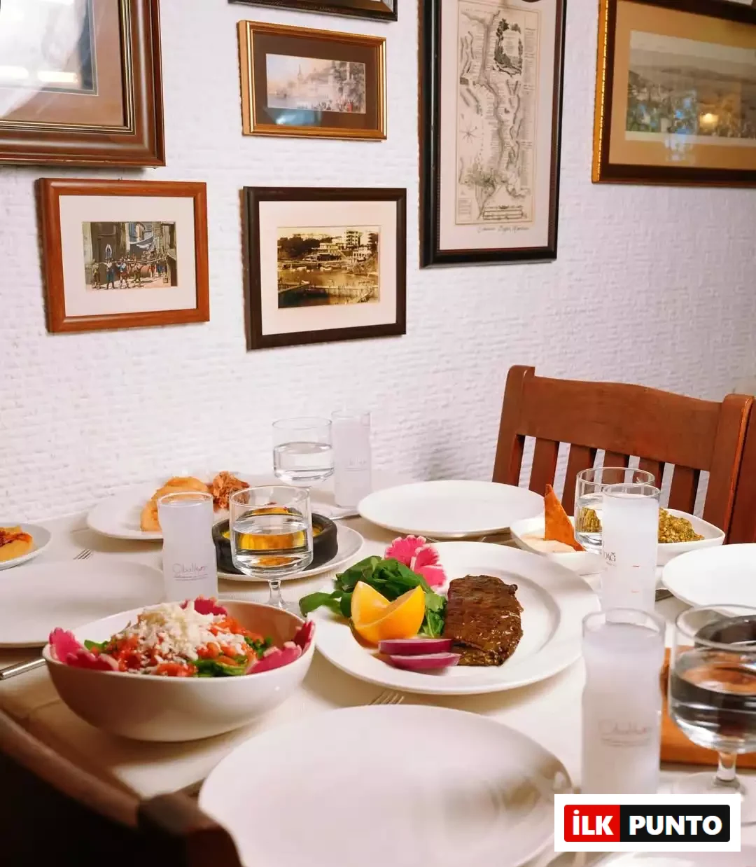 Beyaz, dokulu duvarında farklı çerçeveli tabloların asılı olduğu, üzerinde beyaz örtü serili bir yemek masasının rakı kadehleri, su bardakları, çeşitli mezeler ve ana yemekle donatıldığı bu geleneksel mekân, Şef Duru Akgül'ün keşfettiği lezzet duraklarından birinin samimi atmosferini yansıtıyor.