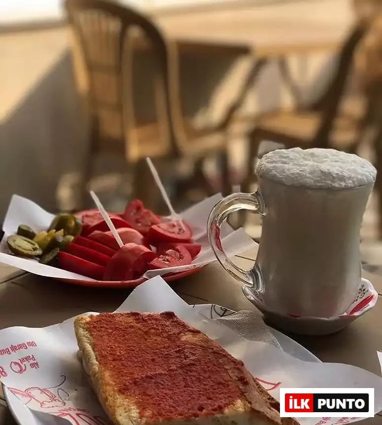 Şeflerin lezzet rotaları listesinde yer alan yol üstü duraklarından biri olan Düzdağ Tost'tan, kıtır ekmeği, erimiş peyniri ve özel salçasıyla ünlü Susurluk tostu, yanında köpüklü ayran, domates ve turşu tabağıyla iştah açıcı bir sunumla masada duruyor.