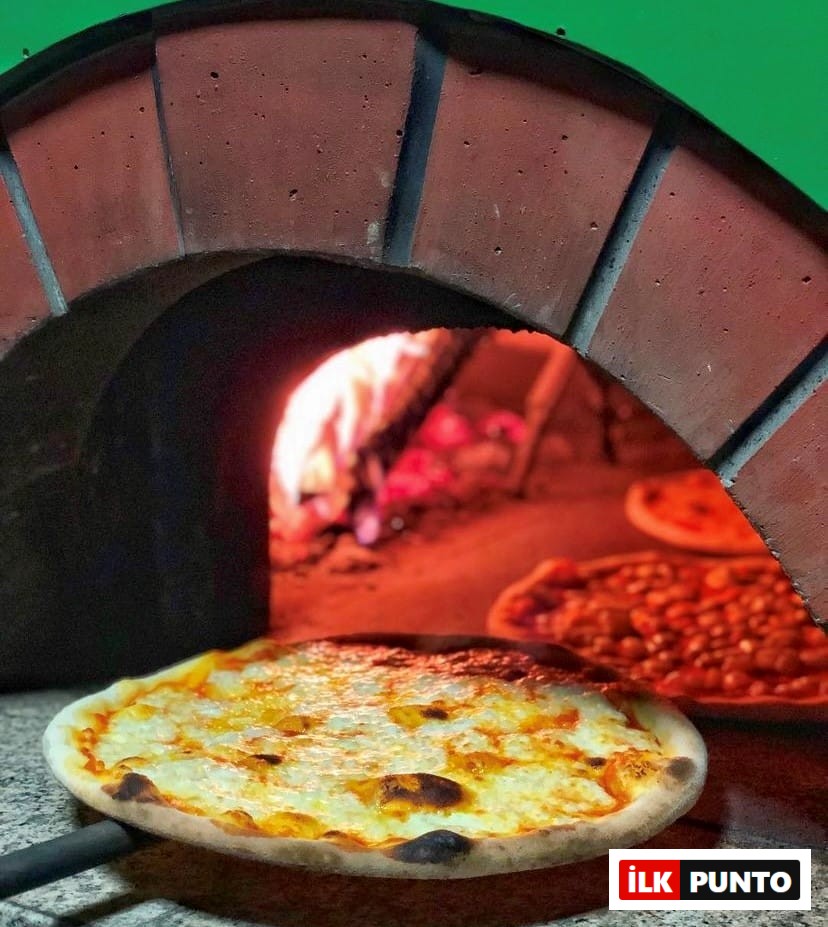 Geleneksel taş fırından yeni çıkmış, kenarları hafifçe kararmış, üzerinde erimiş peyniri kabarcıklar oluşturan lezzetli bir pizza, arkasında fırında pişmeye devam eden diğer pizzalarla birlikte, Etiler ve Akatlar'ın en iyi mekanlarında sunulan nefis tatlardan birine işaret ediyor.
