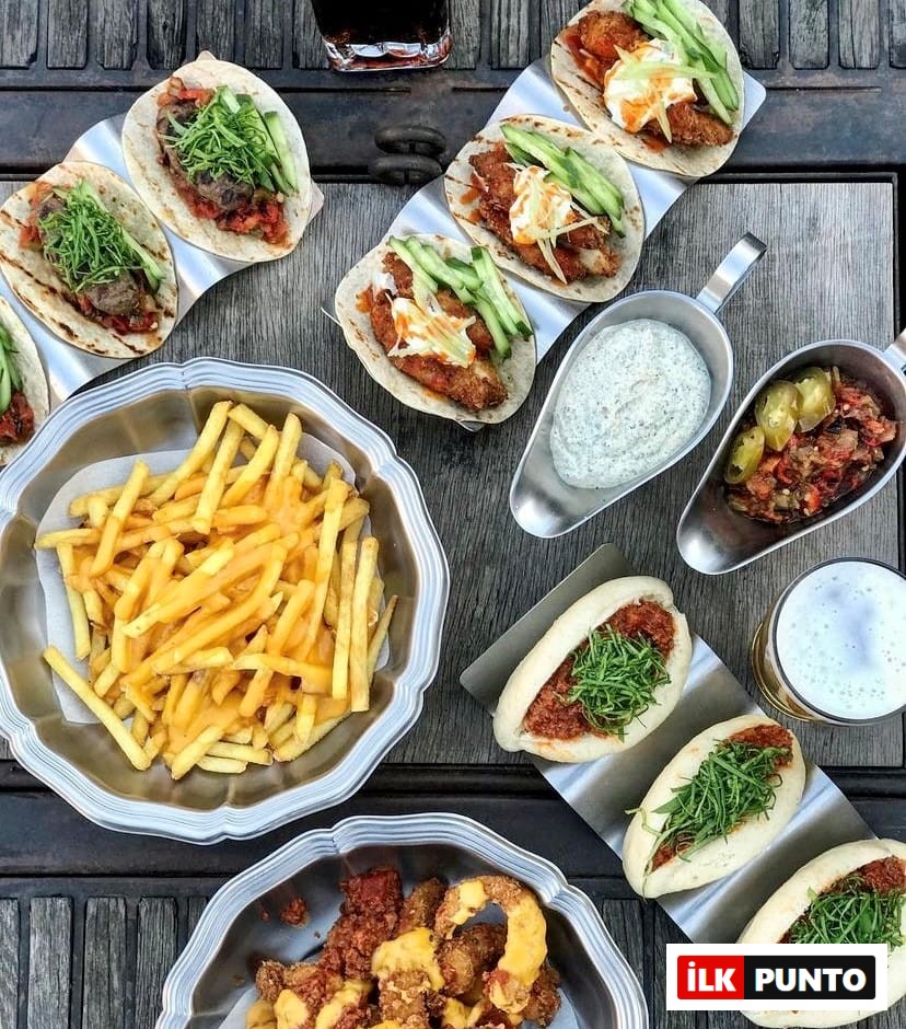 Bir ahşap masa üzerinde servis edilen, Etiler ve Akatlar'ın gözde sokak lezzetlerinden Dirty Hands restoranına özgü bol malzemeli tavuklu ve dana etli tacolar, yeşillikli bao sandviçler, peynirli patates kızartması ve çıtır tavuk parçalarından oluşan iştah açıcı bir ziyafet sofrası, burayı gurmelerin radarında tutan bir lezzet durağı olduğunu kanıtlıyor.