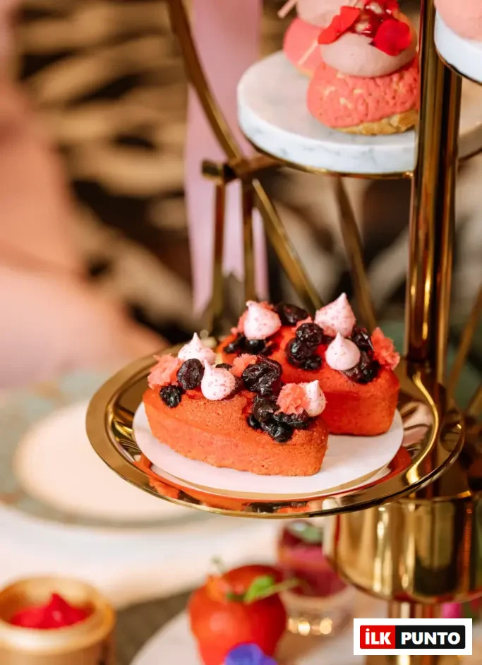 Shangri-La Bosphorus Pinktober Afternoon Tea menüsünden pembe meyveli mini pastalar ve yenilebilir çiçek süslemeleriyle zarif sunum