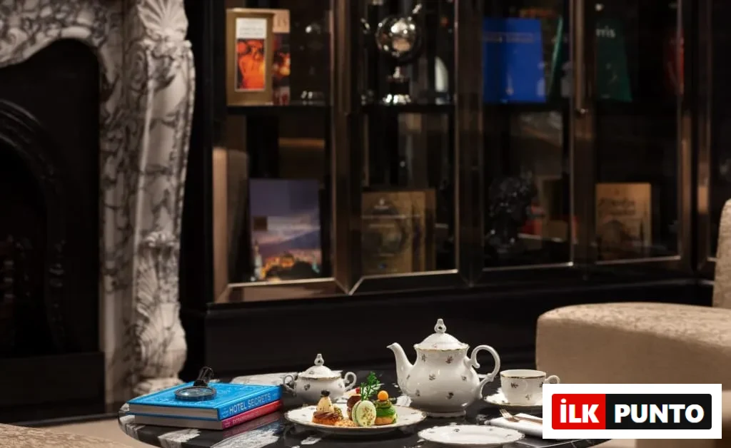 Sanasaryan Han The Library salonunda antika kitaplarla çevrili masa üzerinde zarif çay takımı ve atıştırmalıklar – Afternoon Tea İstanbul