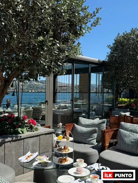 İstanbul Boğazı'na nazır, yemyeşil ağaçların gölgesindeki şık terasta, beş çayı ikramlarıyla donatılmış cam masalar ve çevresindeki konforlu oturma grupları, Boğaz'ın masmavi suları ve karşı kıyıdaki yerleşimlerle bütünleşen huzurlu bir İstanbul çay saati deneyimi sunuyor.
