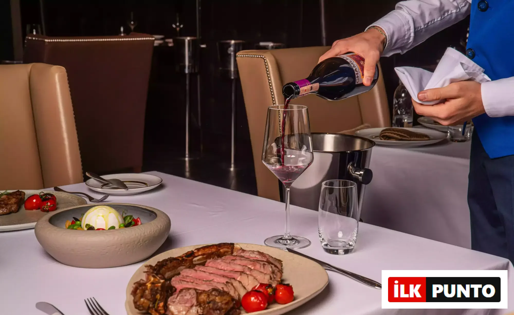 JW Steakhouse’ta dilimlenmiş tomahawk steak ve köz domates eşliğinde kırmızı şarap servisi, JW Marriott Hotel Ankara