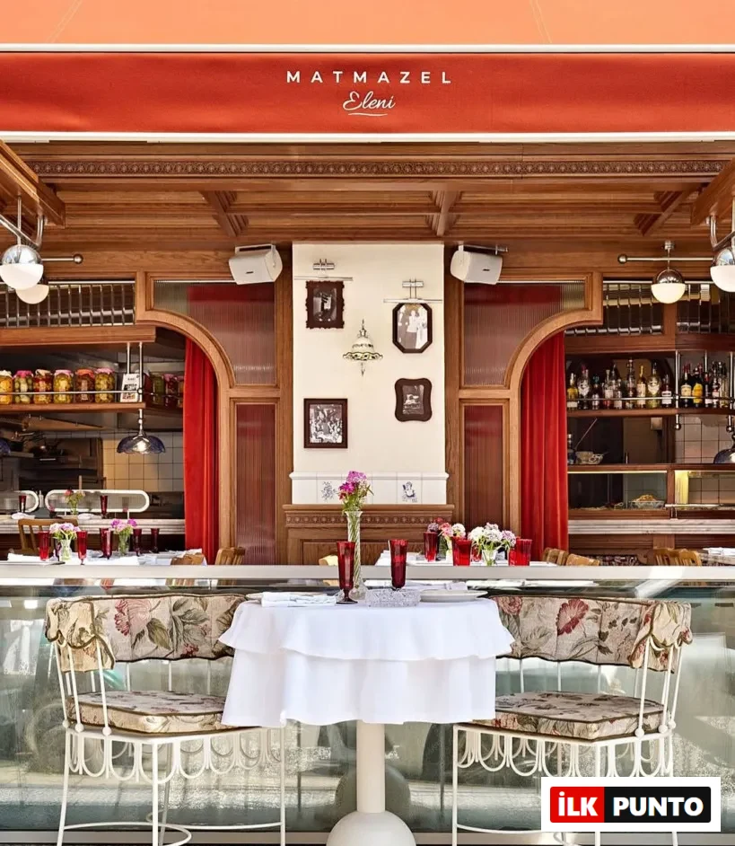 Matmazel Eleni, Suadiye restoran dış görünümü – Kırmızı tente altında çiçek desenli sandalyeler ve beyaz örtülü masalarla şık bir ambiyans.