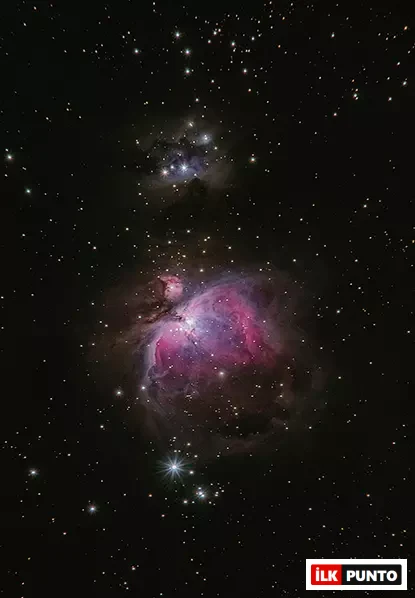 Karanlık uzay fonunda mor-pembe tonlarda parlayan Orion Bulutsusu.