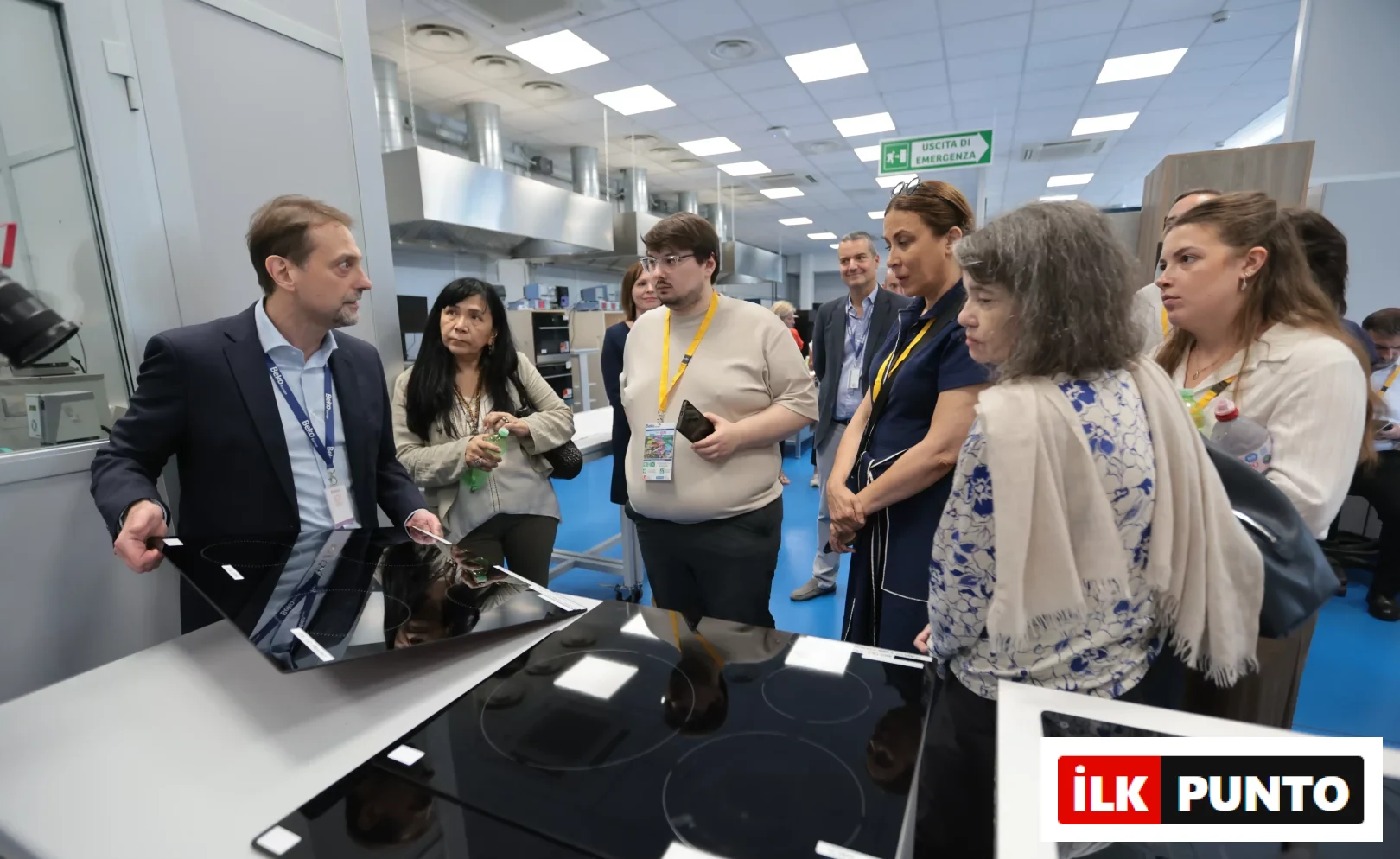 Beko Europe'un Kuzey İtalya'daki tasarım kalbi Cassinetta'da, bir teknoloji uzmanı, ziyaretçilere modern mutfakların geleceğini şekillendiren ankastre pişirici ürünlerin yeni teknoloji ve tasarım detaylarını yansıtan parlak siyah cam yüzeyleri tanıtırken, grubun ürün geliştirme ve inovasyon süreçlerine ışık tutuyor.