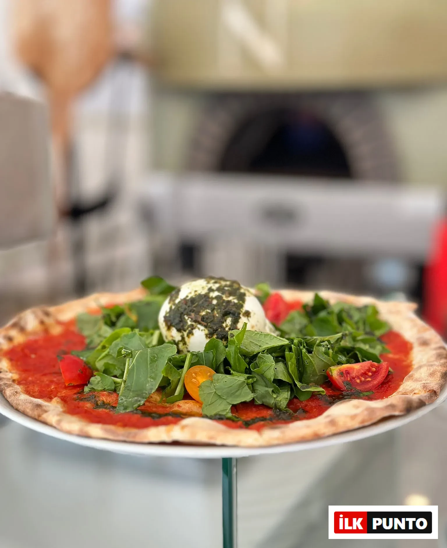 İlk Punto Salvatore Cannetiello – Şeflerin Lezzet Rotaları. Şefin Il Pellicano restoranında burrattalı domatesli pizza sunumu.
