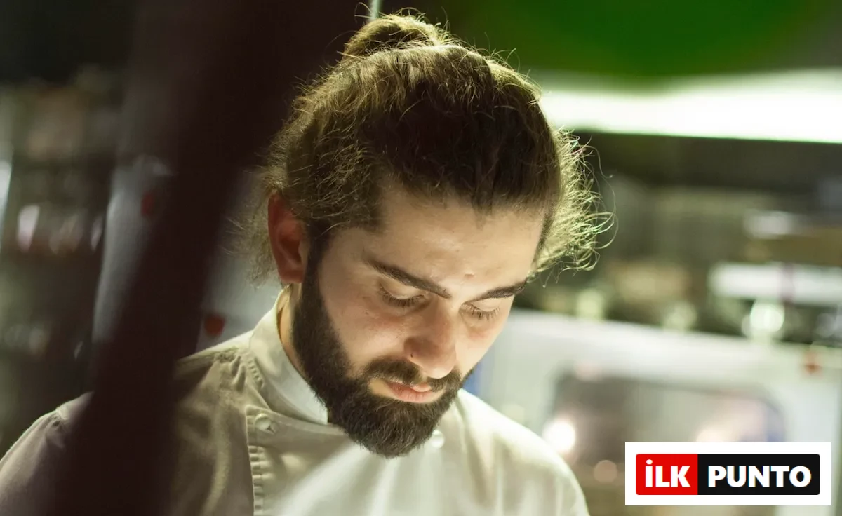 Beyaz şef ceketini giymiş, saçları topuz yapılmış ve gür sakallı Şef İbrahim Tunç, sürdürülebilir gastronomi anlayışıyla oluşturduğu eşsiz lezzet rotalarını ve mutfak felsefesini düşünürcesine gözleri kapalı veya aşağı doğru odaklanmış bir şekilde görünüyor.