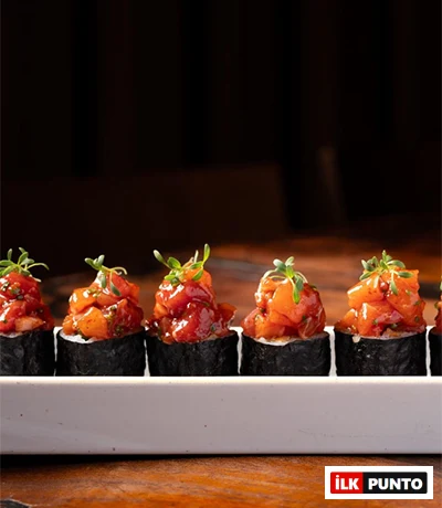 Beyaz dikdörtgen bir tabakta özenle sıralanmış, koyu renk nori ile sarılıp üzerleri nar gibi doğranmış taze balık ve yeşil filizlerle süslenmiş iştah açıcı sushi roll'ları, İstanbul'un en seçkin sushi restoranlarında sunulan Uzak Doğu mutfağının estetik ve lezzet dolu yüzünü gözler önüne seriyor.