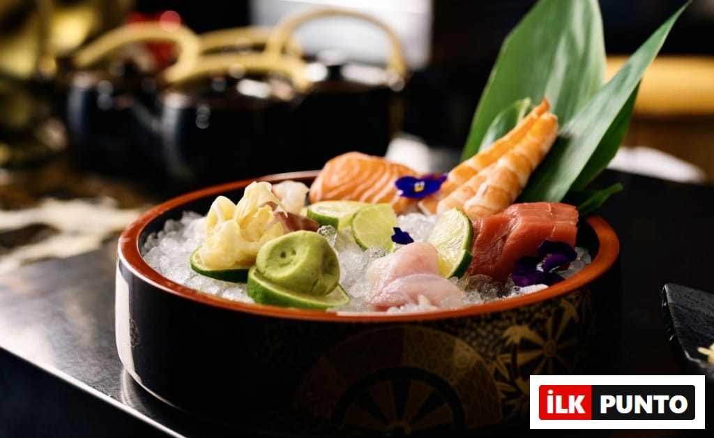 Buz üzerinde taze somon, orkinos, karides dilimleri, yanında misket limonu, wasabi ve zencefil turşusu ile sunulan bu göz alıcı sashimi tabağı, İstanbul'un en popüler sushi restoranlarında sunulan Uzak Doğu lezzetlerinin tazeliğini ve sunum kalitesini vurguluyor.